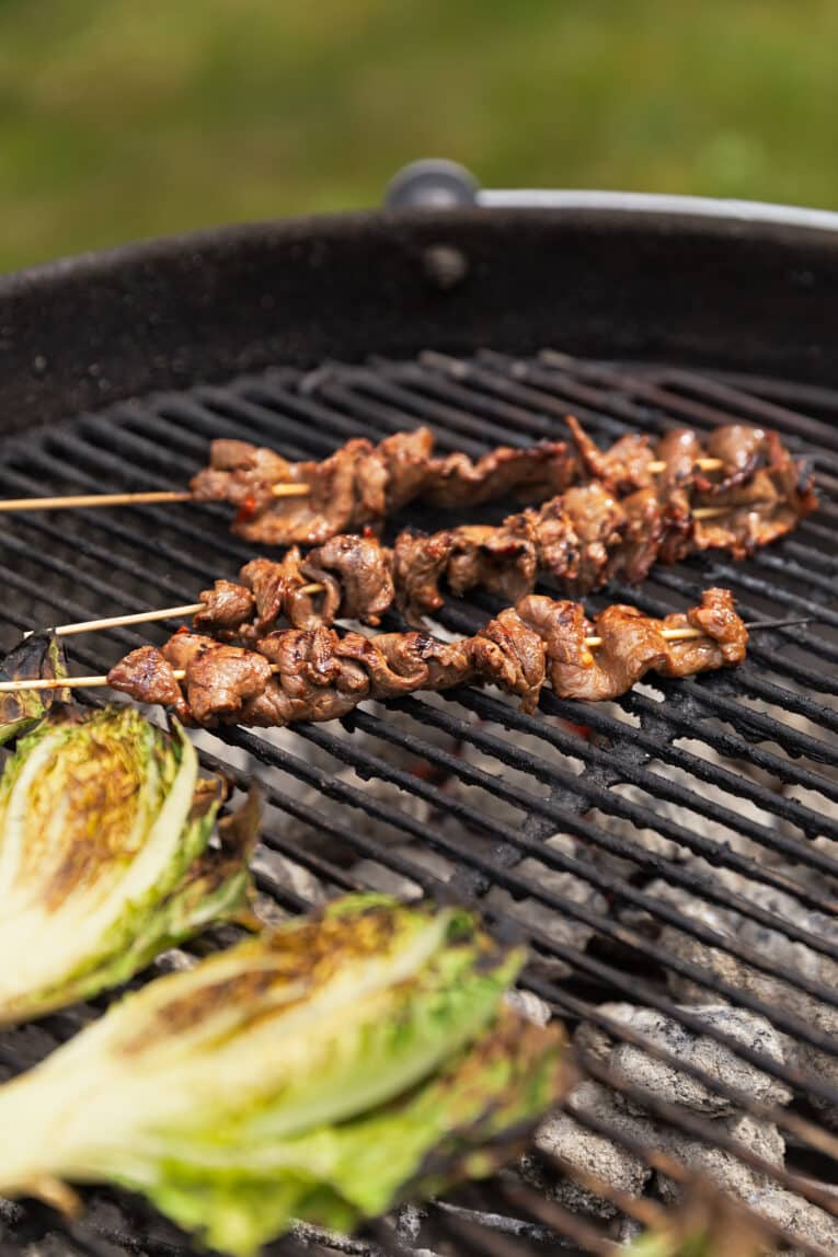 Grillspett med lövbiff på grill med grillad sallad