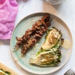 grillade lövbiffsspett på tallrik med grillad sallad