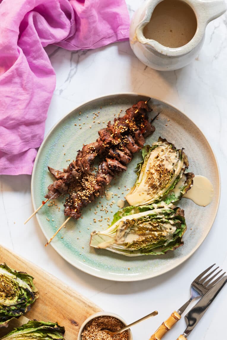 grillade lövbiffsspett på tallrik med grillad sallad